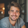 Homme souriant portant un t-shirt gris dans une pièce.